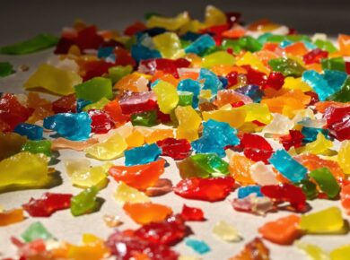 Bunte Jelly Strips, einige zerbrochen, auf neutralem Untergrund.