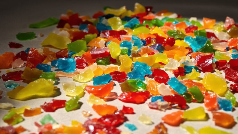 Bunte Jelly Strips, einige zerbrochen, auf neutralem Untergrund.