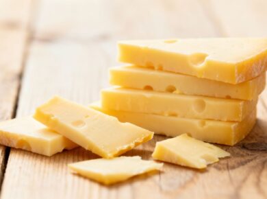 Gestapelte und verstreute Scheiben Raclette-Käse