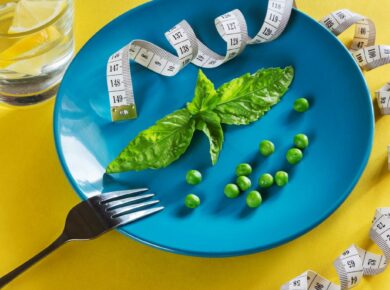 a blue plate topped with green vegetables and measuring tape