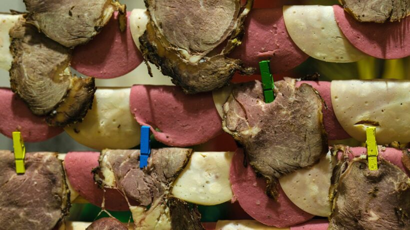 Sliced meats and cheese are dried with clothespins.