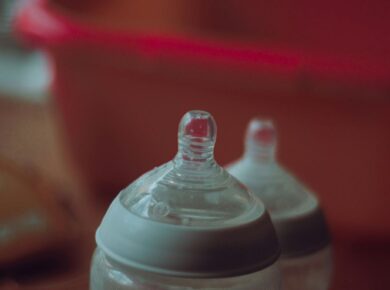 clear plastic feeding bottle on red table